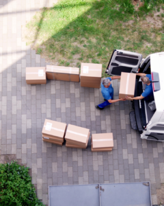 Long-distance movers loading household items into a moving truck in Greenville, NC